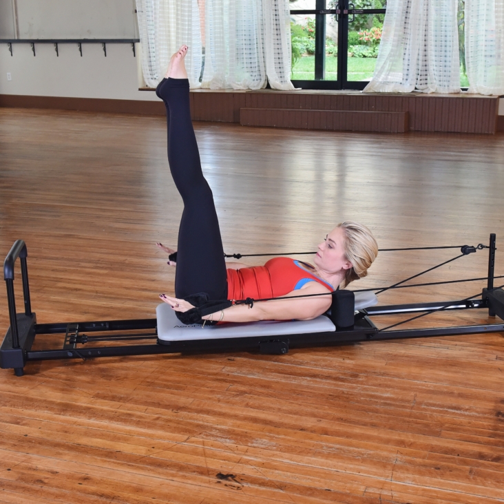 Woman performing on Aeropilates workout bundle.
