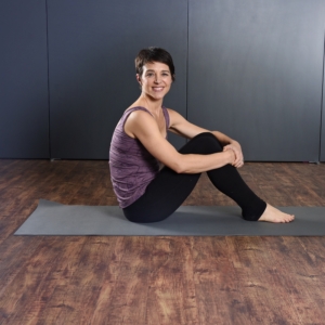 Woman seated on Aeropilates Mat.