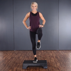 Woman standing one leg on Aerobic Step.