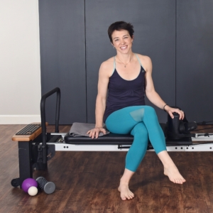 Woman seated smile on pilates.