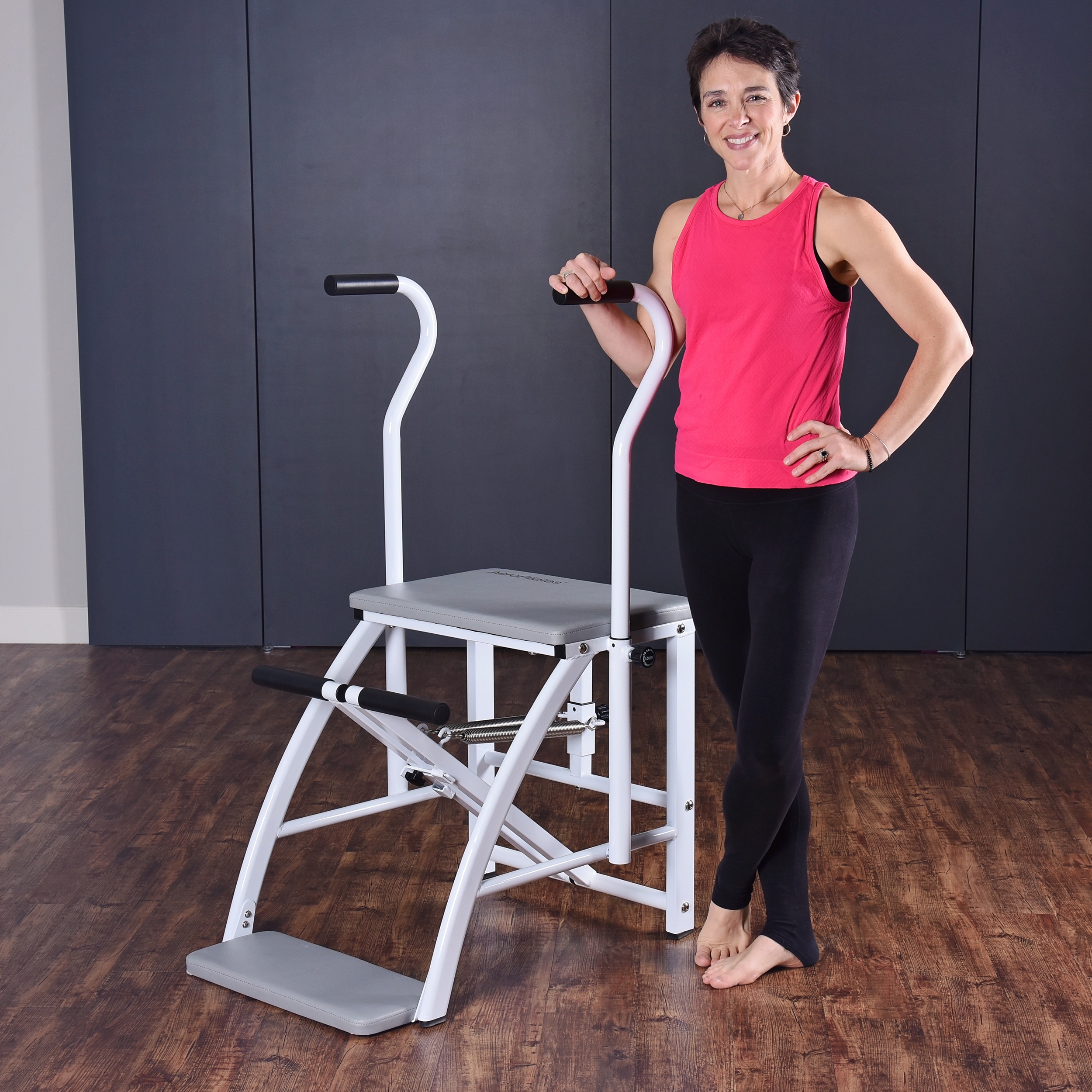 Woman standing aside on Aeropilates Precision Pilates Chair