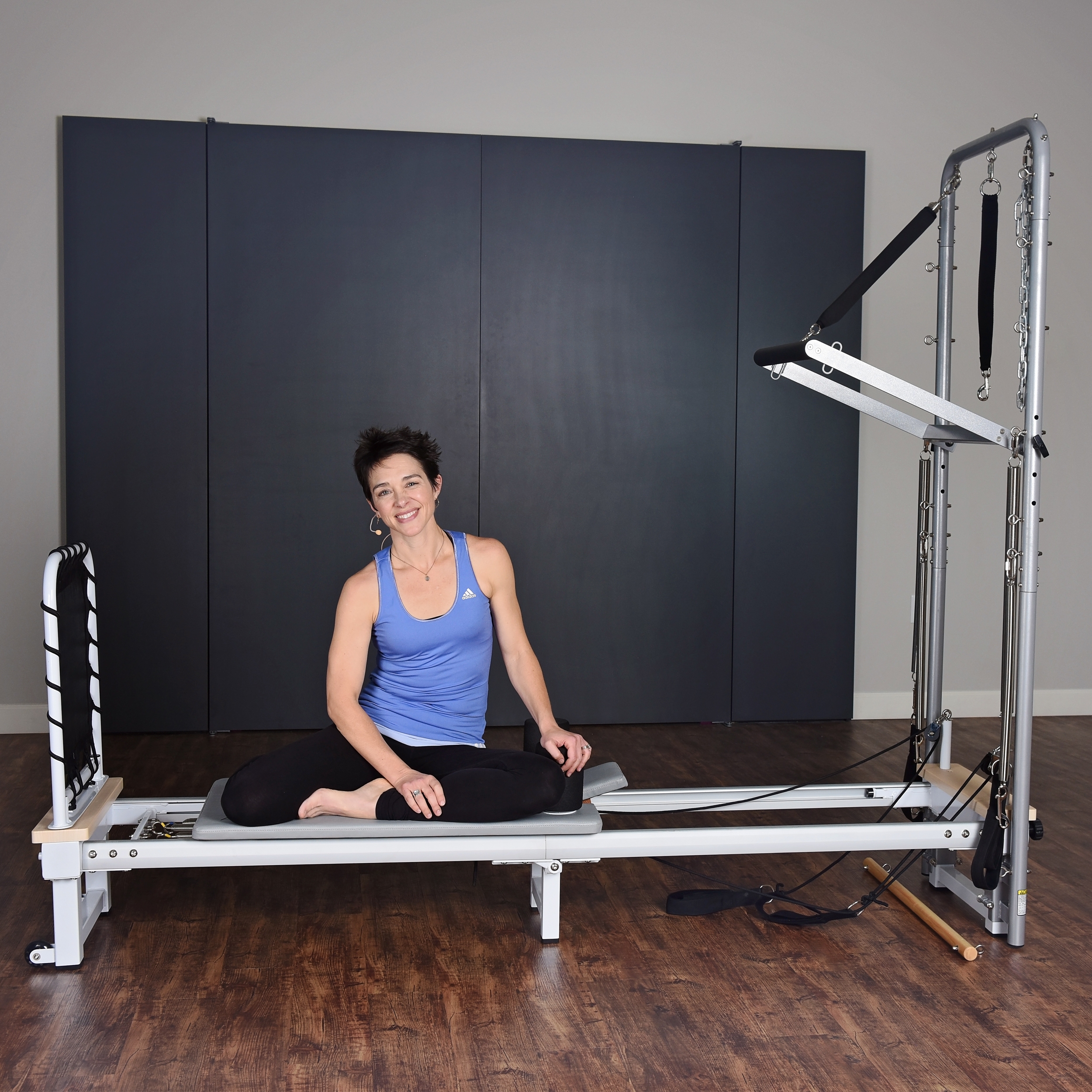 Woman seat on AeroPilates Cadillac Reformer Combo