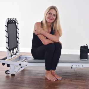 Middle age woman seat on Aeropilates Reformer